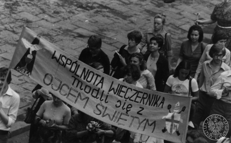 Transparent z hasłem Wspólnota Wieczernika modli się z Ojcem Świętym niesiony przez grupę młodzieży idącą ulicą Skałeczną na spotkanie z Janem Pawłem II na krakowskiej Skałce. 8 VI 1979 r. Sygnatura: IPNKr-7-7-1-1047