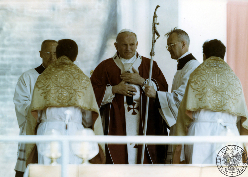 Jan Paweł II za ołtarzem polowym na Wzgórzu Lecha w czasie koncelebry mszy świętej. Pierwszy z lewej ceremoniarz papieski Orazio Cocchetti, drugi z prawej ceremoniarz papieski ksiądz Virgilio Noe. 3 VI 1979 r. Sygnatura: IPNPO-7-7-1-17