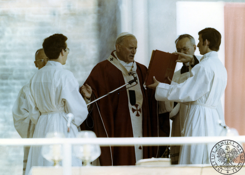 Jan Paweł II za ołtarzem polowym na Wzgórzu Lecha w czasie koncelebry mszy świętej. Pierwszy z lewej ceremoniarz papieski Orazio Cocchetti, drugi z prawej ceremoniarz papieski ksiądz Virgilio Noe. 3 VI 1979 r. Sygnatura: IPNPO-7-7-1-18