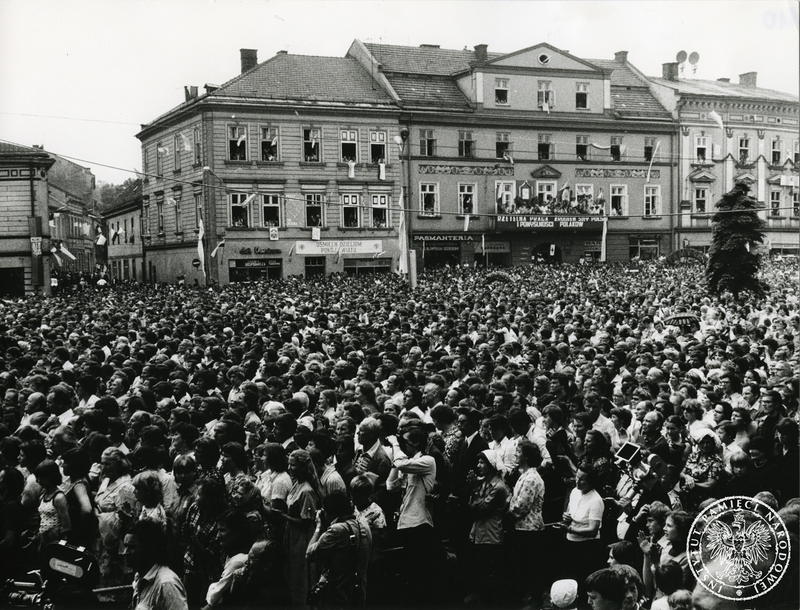 Wierni zgromadzeni na wadowickim rynku w czasie nabożeństwa z udziałem Jana Pawła II, w oddali kamienice przystrojone flagami. Sygnatura: IPNPo-7-7-1-100